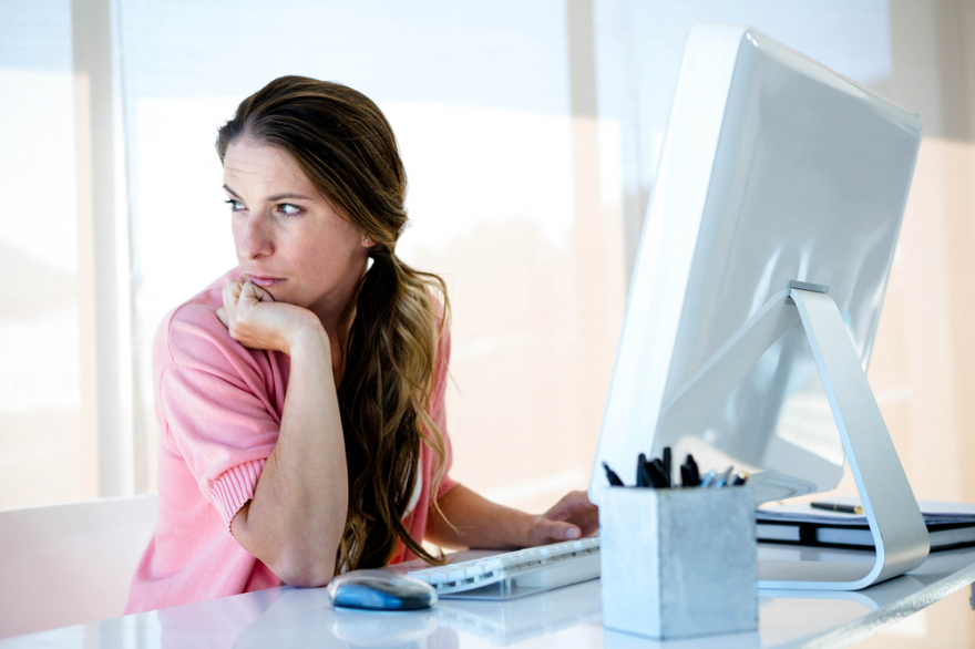 Distracted woman looking away from her computer