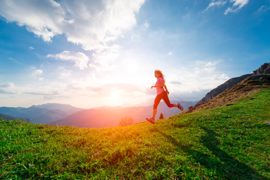 Female athlete trains running in the hillside