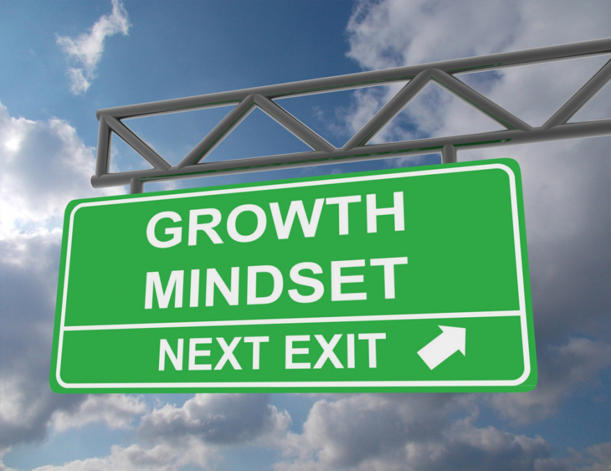 Green overhead road sign with growth mindset