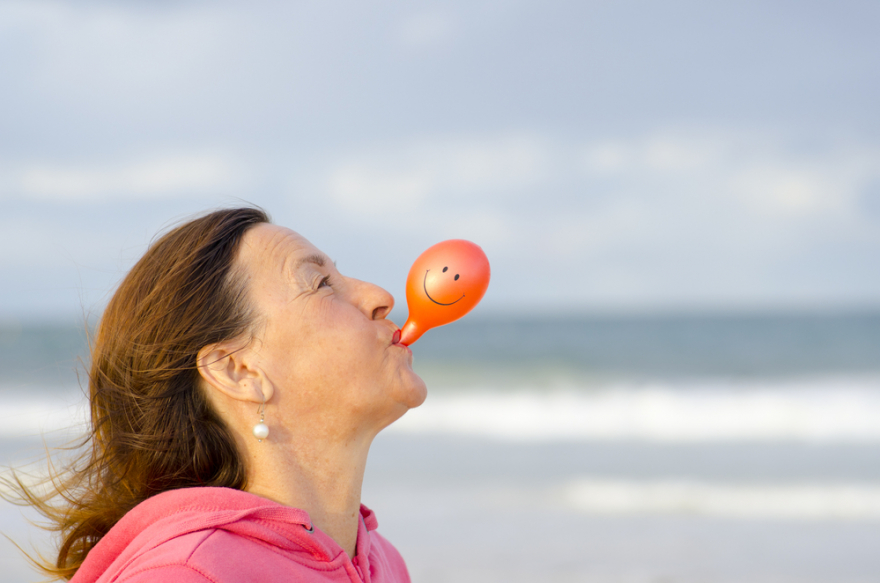 happy joyful woman blowing a balloon