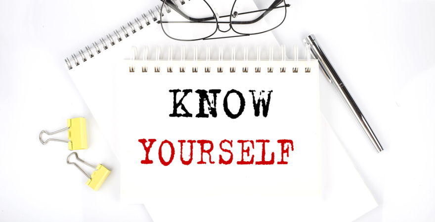 KNOW YOURSELF text on notebook with pen, clips, and glasses