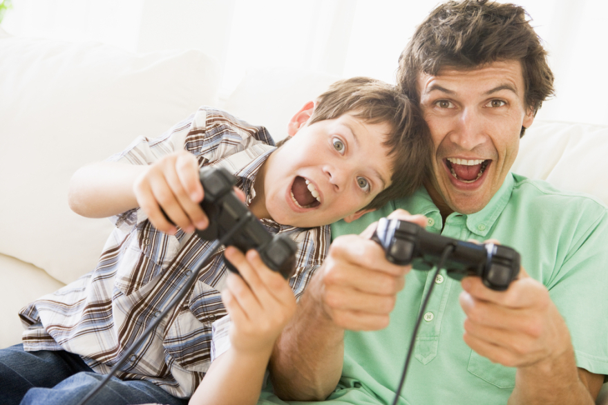 Man and young boy playing video game