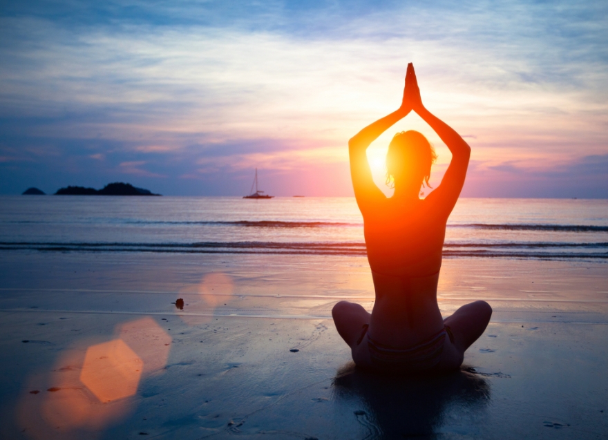 Woman meditating on the beach