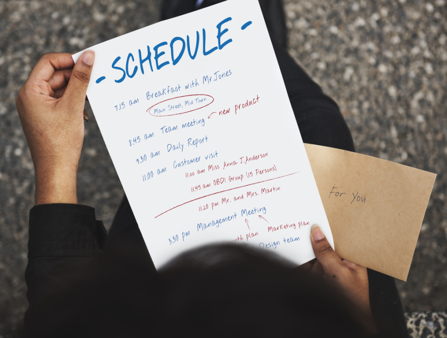 Person holding schedule daily planner