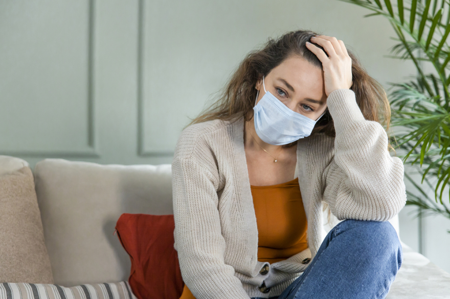 Sad young woman isolated stay at home in protective sterile mask